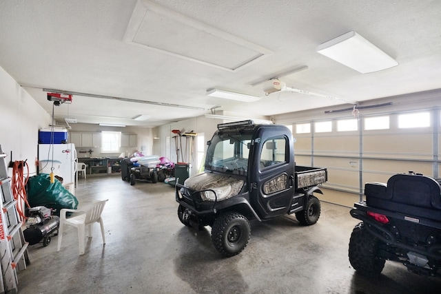 garage with a garage door opener and white fridge