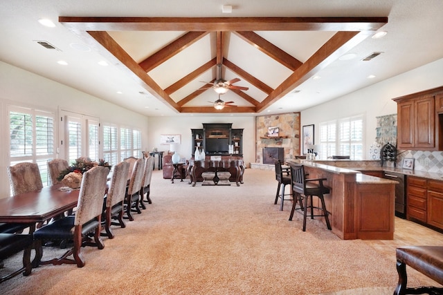 dining space with light carpet, plenty of natural light, high vaulted ceiling, and beamed ceiling