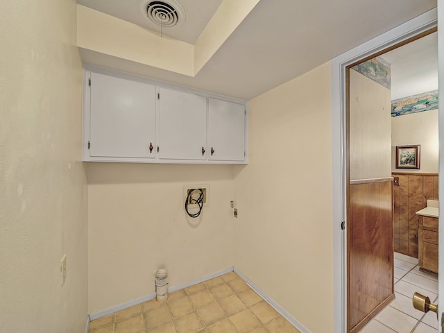 clothes washing area with wood walls, hookup for an electric dryer, washer hookup, and cabinets