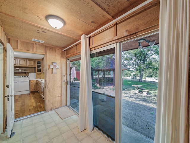 doorway to outside with wood ceiling, wood walls, and light hardwood / wood-style flooring