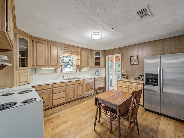 kitchen featuring dishwasher, a textured ceiling, light hardwood / wood-style flooring, white electric stove, and stainless steel fridge