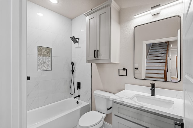 full bathroom featuring tiled shower / bath, toilet, a textured ceiling, and vanity