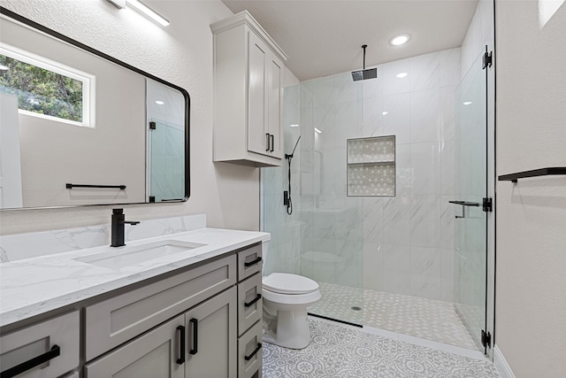 bathroom with tile patterned floors, vanity, walk in shower, and toilet