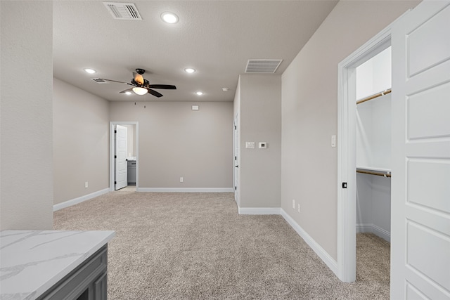 carpeted spare room featuring a textured ceiling and ceiling fan