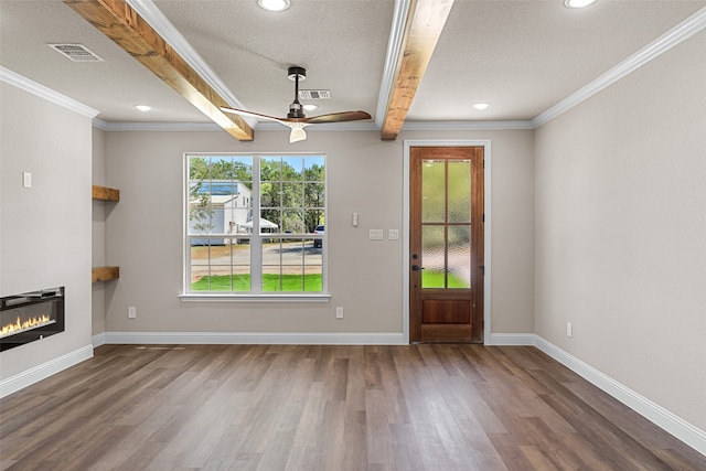 interior space with a wealth of natural light, beam ceiling, hardwood / wood-style floors, and ceiling fan