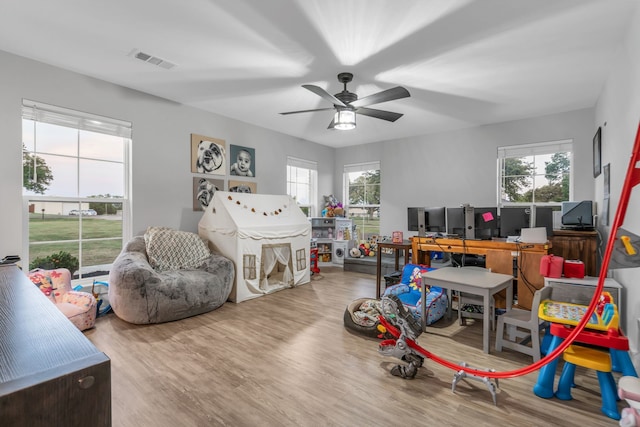 rec room featuring a healthy amount of sunlight, visible vents, ceiling fan, and wood finished floors