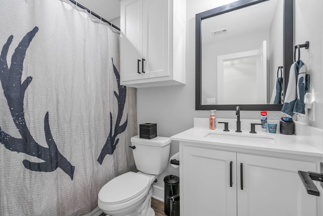 bathroom featuring wood-type flooring, toilet, and vanity