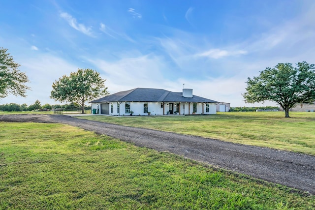 single story home featuring a garage, driveway, a chimney, and a front lawn