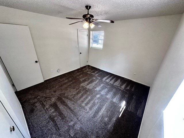 spare room featuring a textured ceiling, carpet floors, and ceiling fan