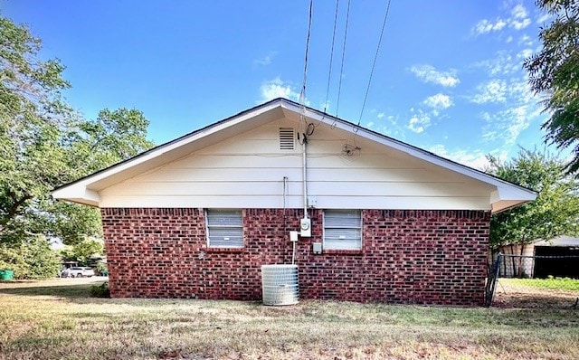 view of property exterior with central AC and a yard