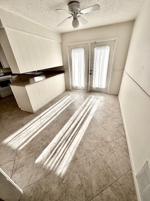 unfurnished room with a textured ceiling and ceiling fan