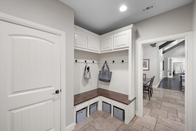 mudroom featuring beam ceiling and light tile patterned flooring