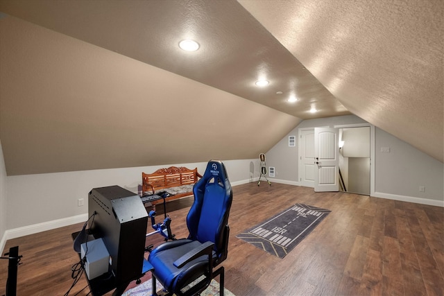 home office featuring a textured ceiling, lofted ceiling, and hardwood / wood-style flooring