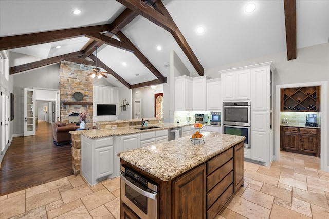 kitchen with a center island, white cabinetry, appliances with stainless steel finishes, light hardwood / wood-style floors, and ceiling fan