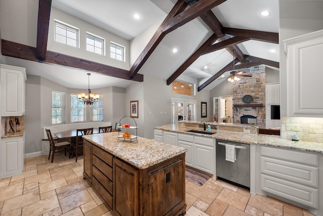 kitchen with a fireplace, sink, white cabinets, and dishwasher