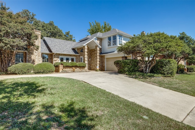 view of front of home with a garage, concrete driveway, brick siding, and a front yard