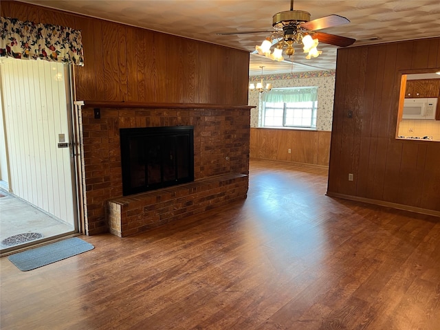 unfurnished living room with hardwood / wood-style floors, wood walls, and a fireplace