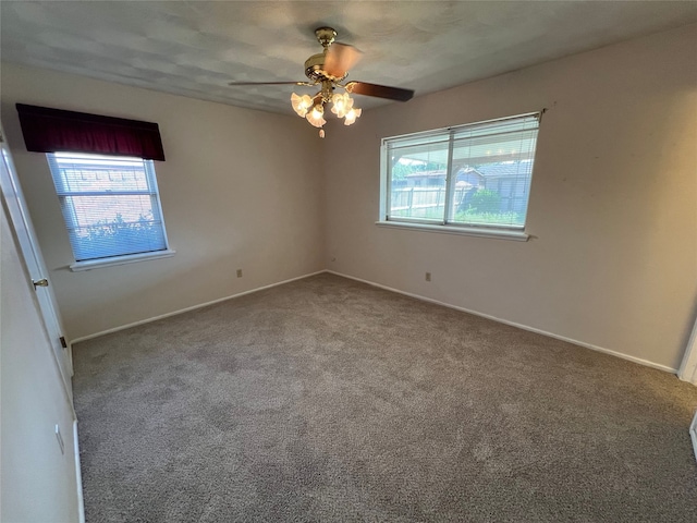 spare room featuring ceiling fan and carpet