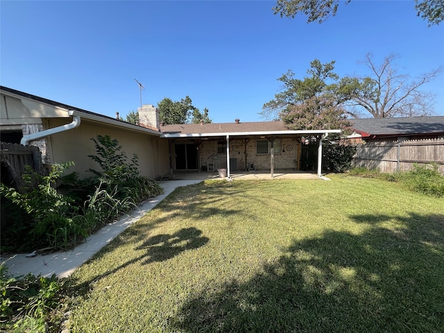 back of property featuring a patio and a yard