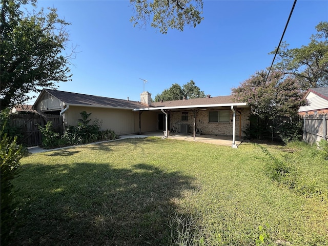 back of house with a patio area and a lawn