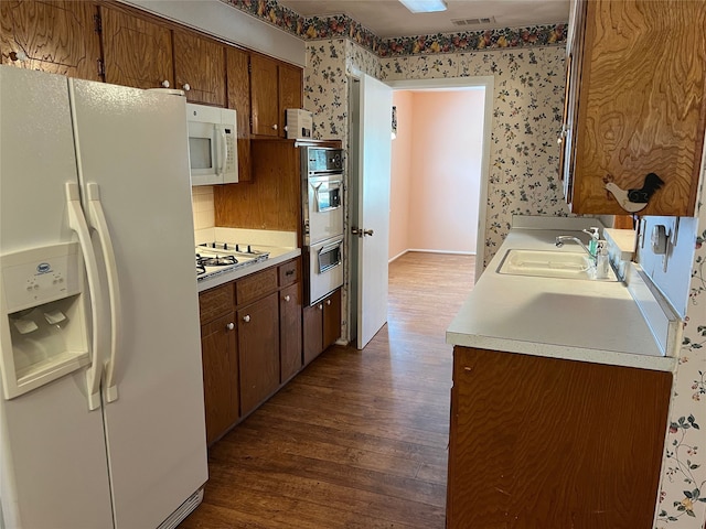 kitchen with sink, stainless steel appliances, and dark wood-type flooring