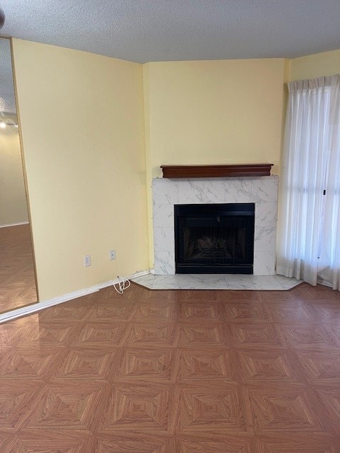 unfurnished living room with parquet floors, a fireplace, and a textured ceiling