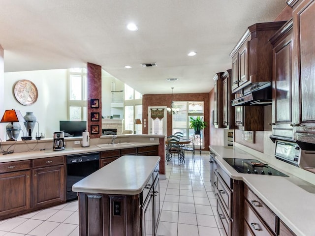 kitchen with light tile patterned floors, light countertops, a sink, under cabinet range hood, and black appliances