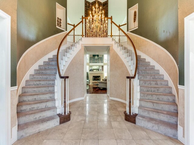 foyer with a notable chandelier, a towering ceiling, and tile patterned floors