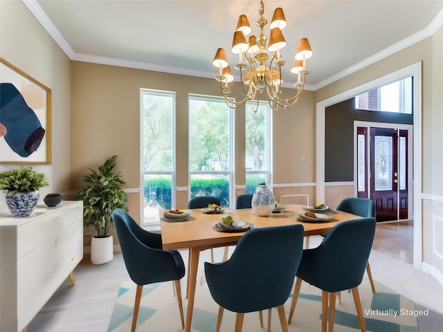 dining area featuring an inviting chandelier, ornamental molding, and wainscoting