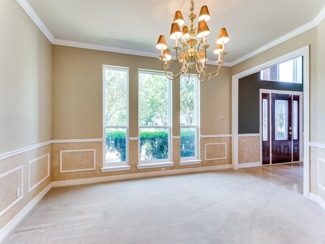 interior space with a wainscoted wall, ornamental molding, a chandelier, and carpet flooring