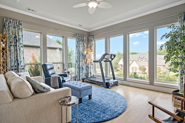 living room featuring wood-type flooring, ceiling fan, and crown molding