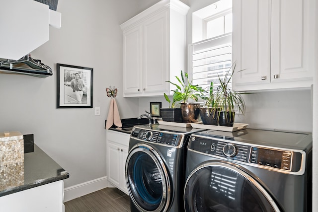 clothes washing area featuring cabinets, washer and dryer, sink, and dark hardwood / wood-style flooring