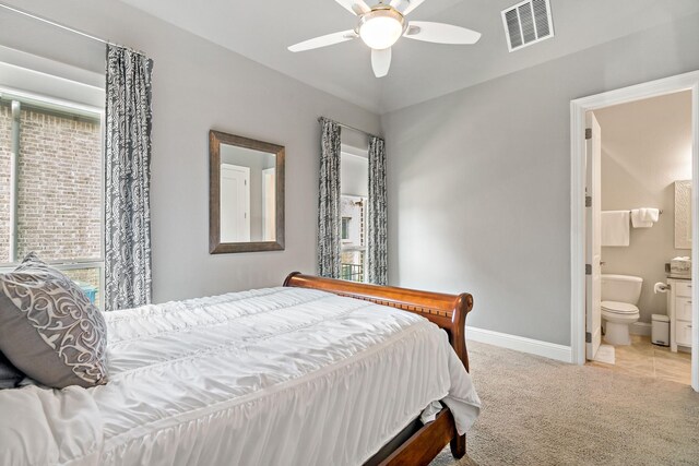 carpeted bedroom with ensuite bathroom and ceiling fan