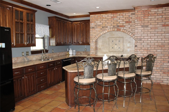 kitchen with black fridge, sink, tile patterned floors, and light stone counters