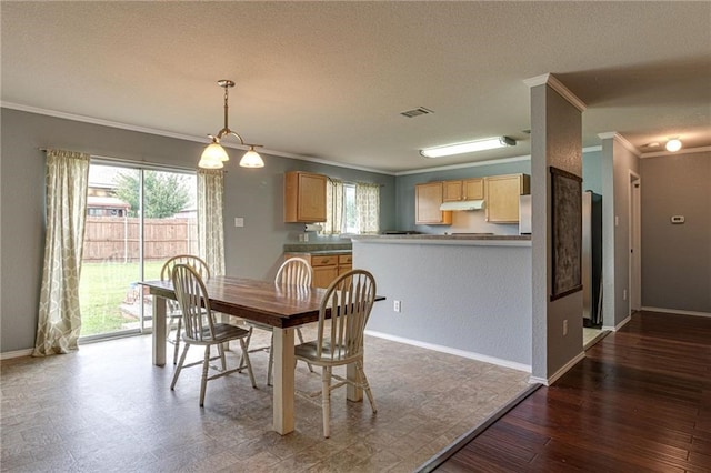 dining space with a textured ceiling, hardwood / wood-style floors, and ornamental molding