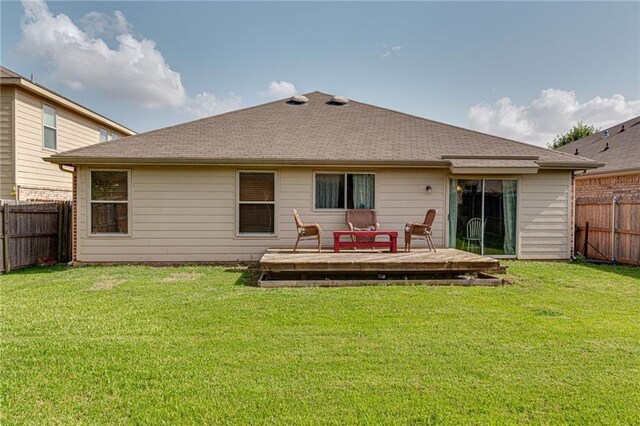 rear view of property featuring a yard and a wooden deck