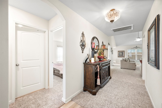 corridor featuring light carpet and lofted ceiling