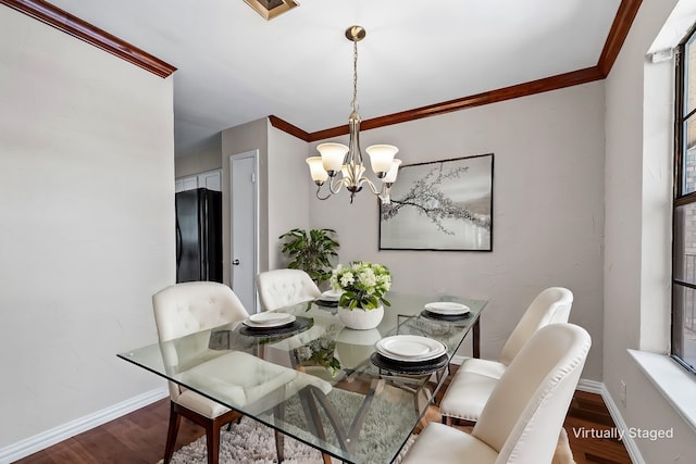 dining space featuring a chandelier, ornamental molding, wood finished floors, and baseboards