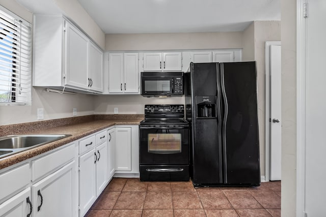 kitchen with white cabinets, light tile patterned flooring, and black appliances