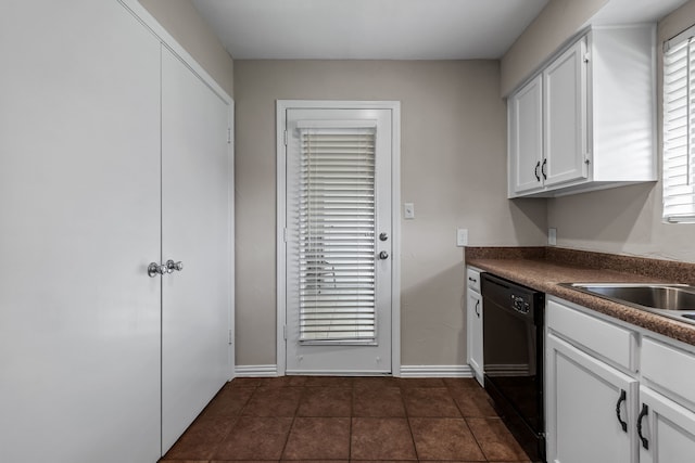 kitchen featuring white cabinets, black dishwasher, and dark tile patterned floors