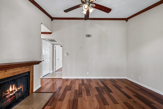 unfurnished living room featuring a fireplace with flush hearth, wood finished floors, baseboards, visible vents, and crown molding