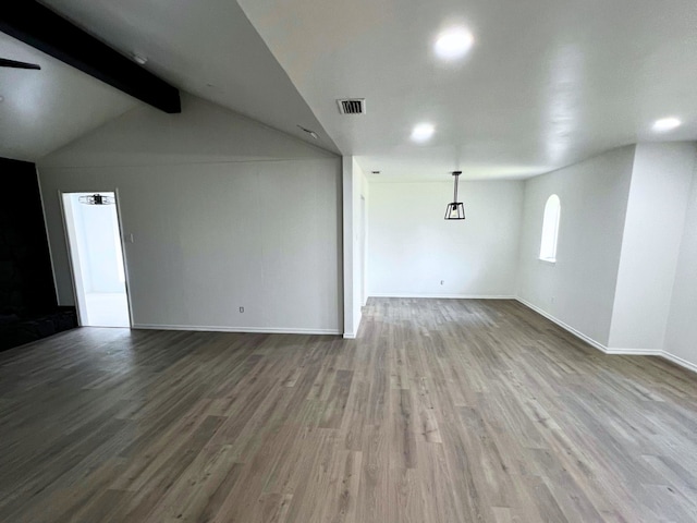 unfurnished room with lofted ceiling with beams and wood-type flooring