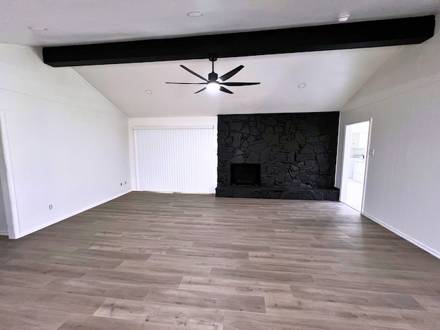 unfurnished living room featuring a fireplace, ceiling fan, lofted ceiling with beams, and wood-type flooring