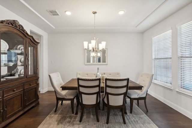 dining space featuring an inviting chandelier, a wealth of natural light, and dark hardwood / wood-style floors