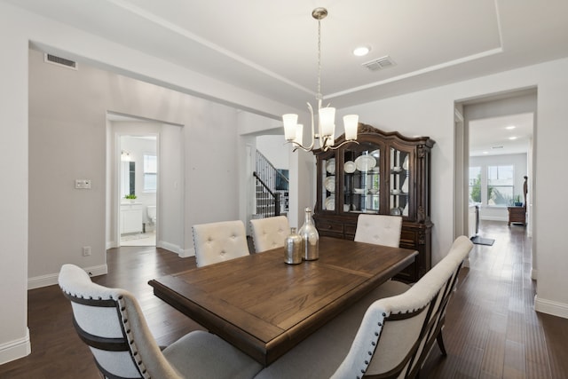 dining area featuring dark wood-type flooring and an inviting chandelier