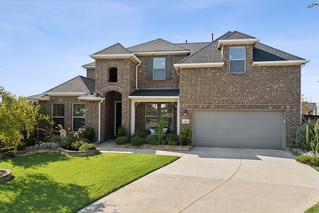 view of front of home featuring a shingled roof, a front yard, brick siding, and driveway