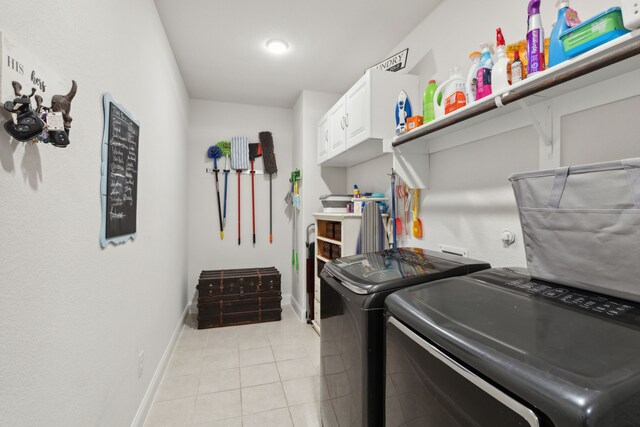 laundry room with washing machine and dryer, light tile patterned floors, and cabinets