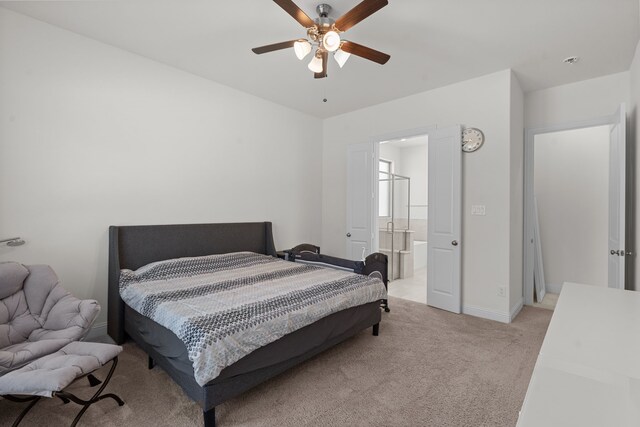 carpeted bedroom with ceiling fan and ensuite bath