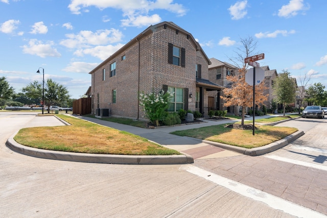 view of side of property featuring cooling unit and a lawn