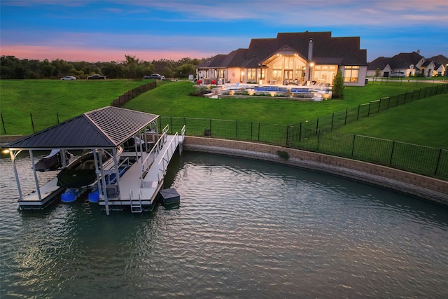 dock area featuring a fenced in pool, a water view, and a lawn